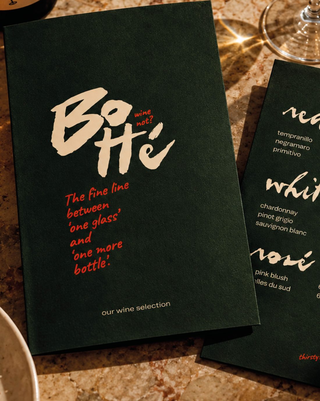 The green Botté menu on a marble table