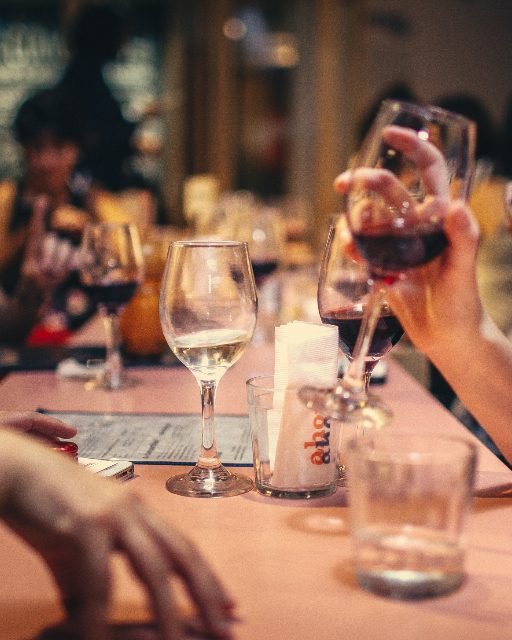 Friends at a long table with wine and candlelight